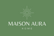 A square green graphic with a white sunburst icon above the text 'MAISON AURA HOME' in white serif and sans-serif lettering.
