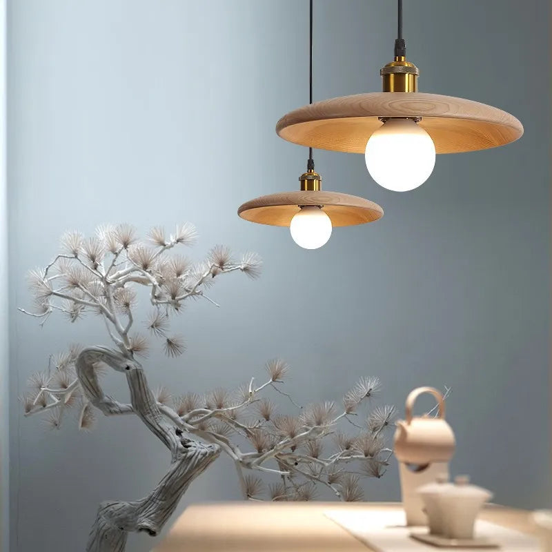 Wooden pendant lights with white bulbs hanging against a light blue wall.