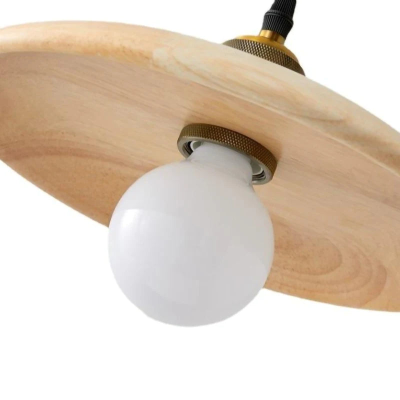 Close-up of a light bulb inside a wooden lampshade on a white background