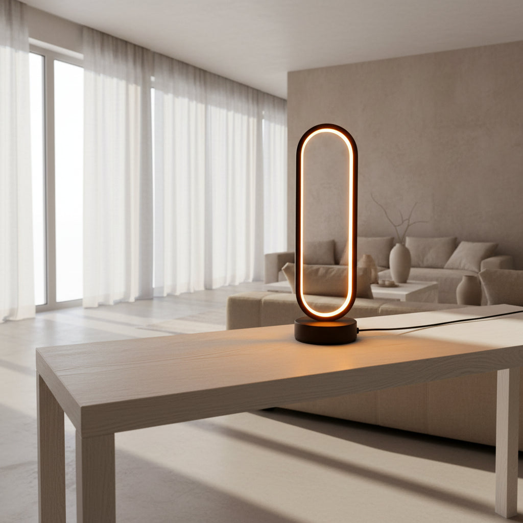 Modern table lamp with a warm glow on a surface next to flowers and books.