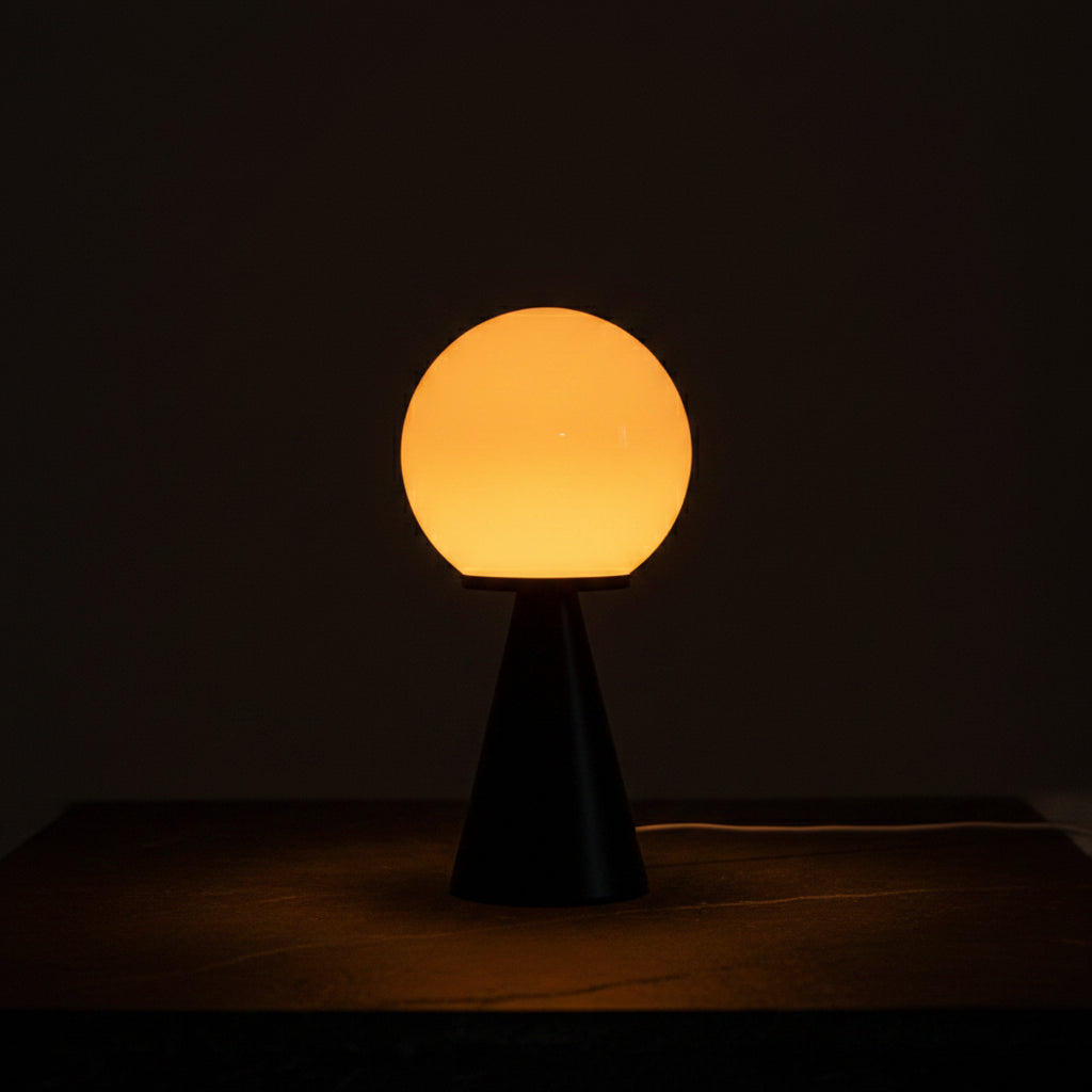 A modern contrast sphere lamp with a glowing warm yellow-orange glass globe and a black cone-shaped base, shown on a wooden windowsill with a book nearby. Text overlays mention 'Glass Contrast Sphere Lamp', 'Usb Power Plug', '3 Color Temperature', and 'Jeda Home Lighting'.