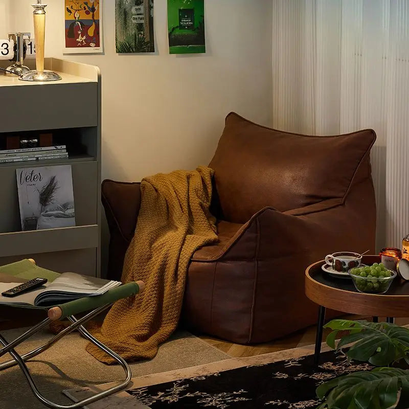 Cozy living room with a brown leather chair, yellow blanket, and small table with a cup.
